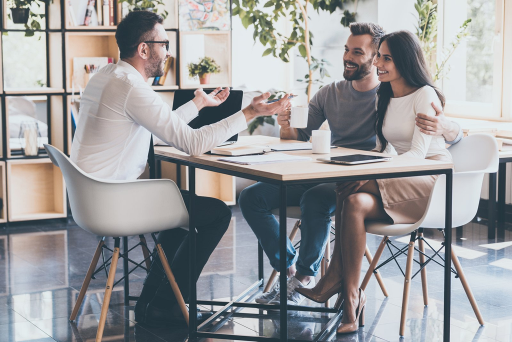 A couple and consultant sharing a conversation around a table