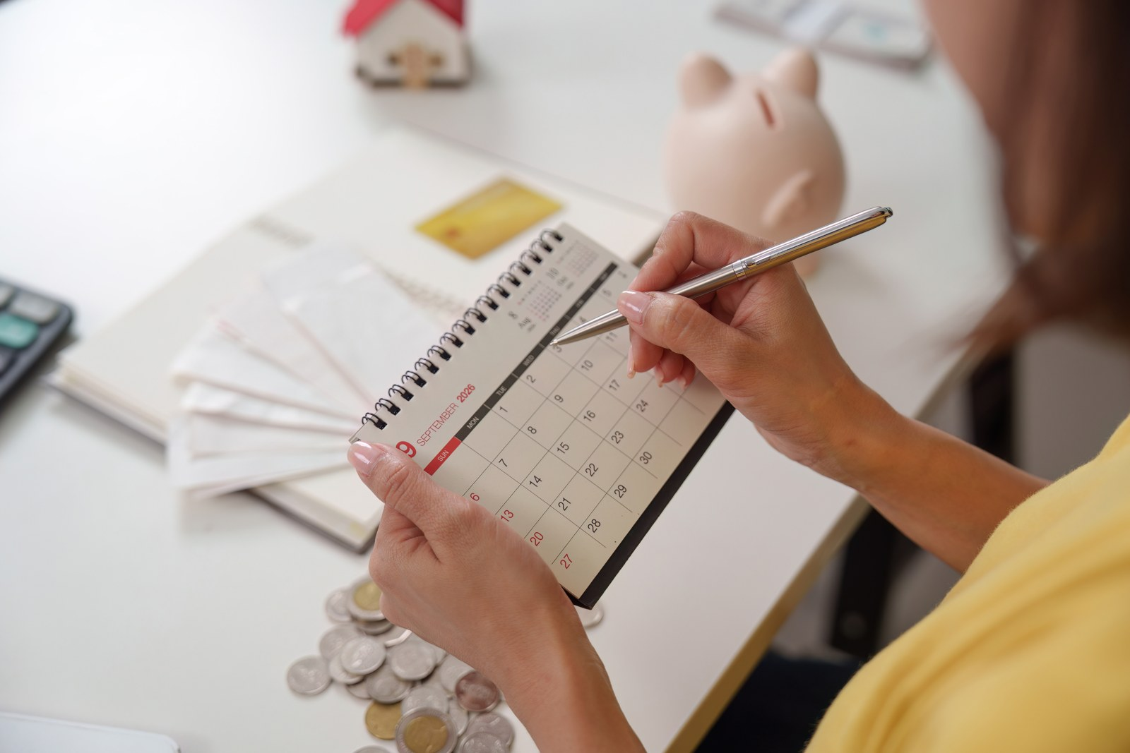 A woman marking a calendar during a regular money-planning check-in
