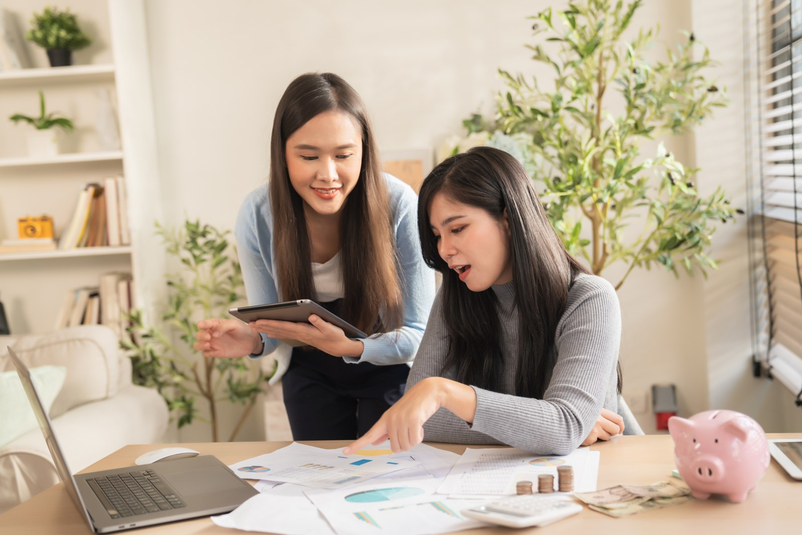 Two women reviewing financial documents together at a desk
