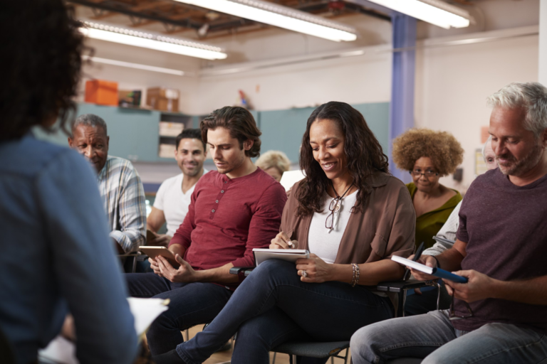 Adults taking notes during a group learning session